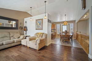 Living area featuring hardwood / wood-style floors, baseboards, and lofted ceiling