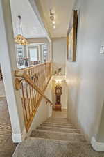 Stairs featuring a textured ceiling and baseboards