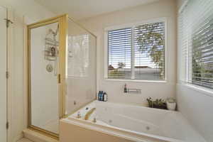 Bathroom featuring a tub with jets and a stall shower