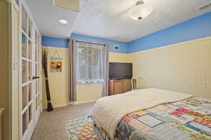 Bedroom with visible vents, carpet, baseboards, a textured ceiling, and french doors