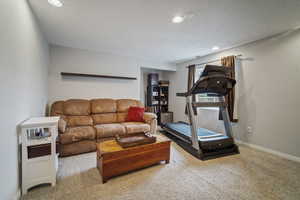 Carpeted living area featuring recessed lighting and baseboards