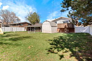 View of yard with an outdoor structure, a storage unit, and a fenced backyard