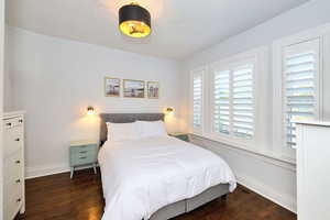 Primary Bedroom with large windows and hardwood floors.