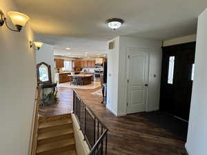 Entryway with recessed lighting, stairs, dark wood-style flooring, and baseboards