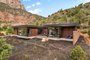 Back of house featuring a deck with mountain view and a chimney