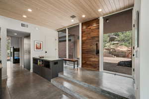 Interior space with recessed lighting, visible vents, wooden ceiling, and concrete flooring