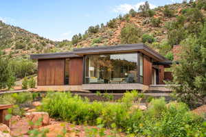 Rear view of house featuring a mountain view and a sunroom