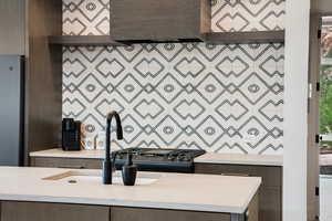 Interior space with light countertops, freestanding refrigerator, and dark brown cabinets