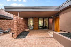 View of exterior entry with a patio