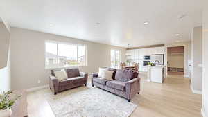 Living area featuring recessed lighting, light wood-style flooring, and baseboards