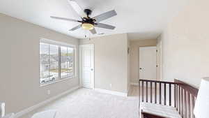 Bedroom with baseboards, visible vents, light carpet, and ceiling fan