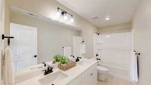 Full bathroom with visible vents, toilet,  shower combination, and a sink