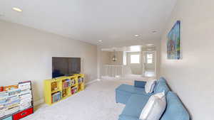 Carpeted living area featuring visible vents, recessed lighting, and baseboards