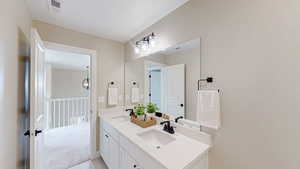 Bathroom featuring double vanity, visible vents, and a sink