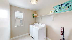 Laundry room featuring washer and dryer, laundry area, and baseboards