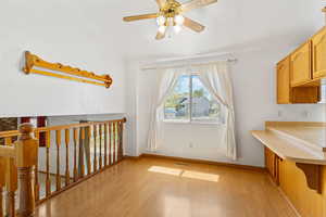 Interior space with visible vents, light wood-type flooring, ceiling fan, and baseboards