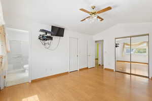 Master bedroom with walk in closets and .75 bathroom, light wood-style flooring.