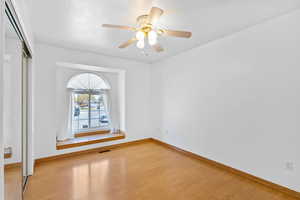 Spare 2nd bedroom featuring wood finished floors, visible vents, and baseboards