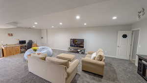 Carpeted basement living room featuring baseboards and recessed lighting