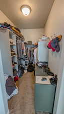 Spacious primary closet featuring carpet floors