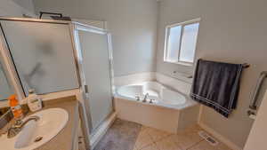 Primary bathroom with a garden tub, a stall shower, vanity, tile patterned flooring, and visible vents