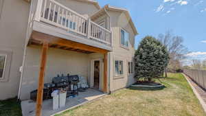 Back of property with fence, a patio area, a yard, and stucco siding