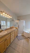Full primary bath with a bath, a sink, a shower stall, and double vanity