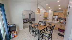Dining room with recessed lighting, vaulted ceiling, arched walkways, light tile patterned flooring, and light colored carpet