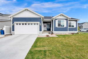 Single story home featuring a front yard, concrete driveway, and an attached garage