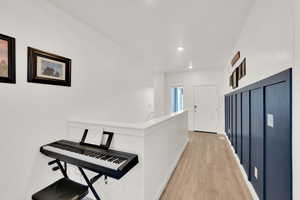 Corridor featuring recessed lighting, baseboards, and light wood finished floors