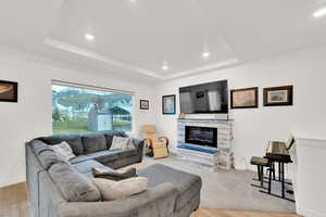 Living room featuring recessed lighting, wood finished floors, and a tray ceiling