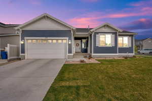 Ranch-style house featuring an attached garage, a front yard, and concrete driveway