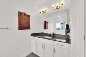 Bathroom with wood finished floors, vanity, and baseboards