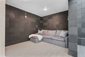 Living area featuring wood finished floors and tile walls