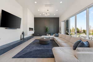 Living area featuring recessed lighting, a fireplace, a notable chandelier, visible vents, and wood finished floors