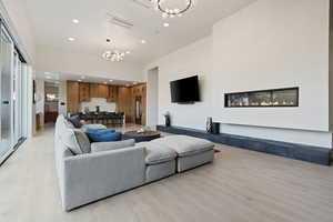 Living area featuring a chandelier, light wood-type flooring, and recessed lighting