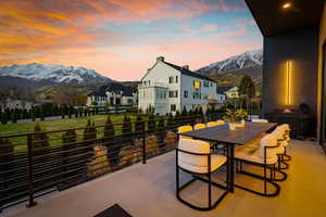 Patio terrace at dusk featuring a residential view, a mountain view, grilling area, and a balcony