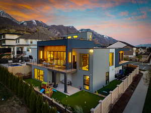 Rear view of property featuring a patio, a mountain view, a fenced backyard, and a balcony