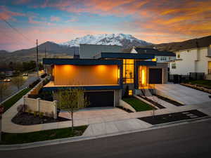 View of front of property featuring driveway, fence, a mountain view, and a garage