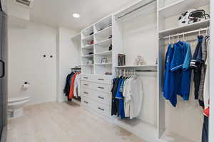 Walk in closet featuring visible vents and wood finished floors