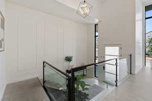 Stairs featuring wood finished floors, a chandelier, and baseboards