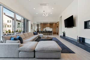 Living room with recessed lighting, visible vents, a notable chandelier, and light wood-style floors