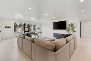 Living room featuring recessed lighting, baseboards, and light wood-type flooring