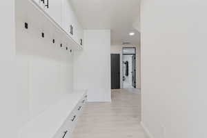 Mudroom featuring light wood finished floors, recessed lighting, visible vents, and baseboards