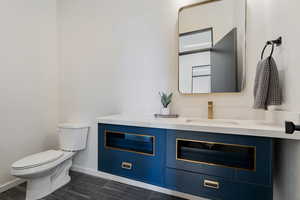 Bathroom featuring toilet, vanity, and baseboards