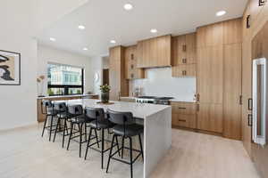 Kitchen with a center island, light countertops, a kitchen breakfast bar, and light wood-style flooring