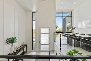 Doorway to outside with recessed lighting and expansive windows