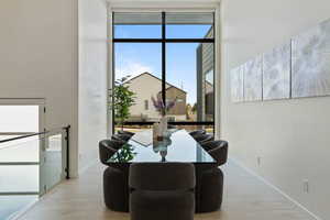 Dining room featuring floor to ceiling windows, wood finished floors, and baseboards