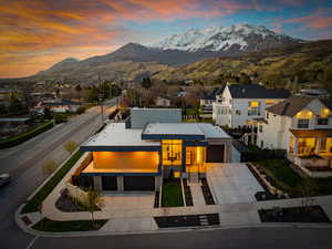 Contemporary house with a mountain view, fence, driveway, and metal roof