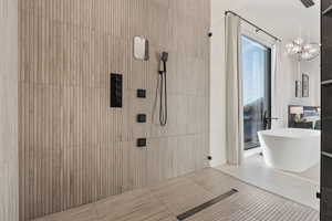 Bathroom featuring an inviting chandelier and tiled shower